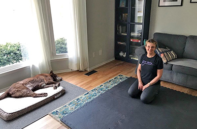 High view shot into living room with woman on mat 